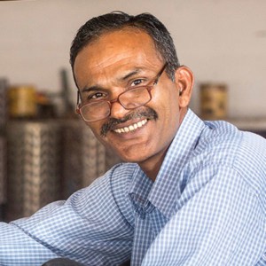 Khalil Ahmed, an Indian man, smiling at a table.
