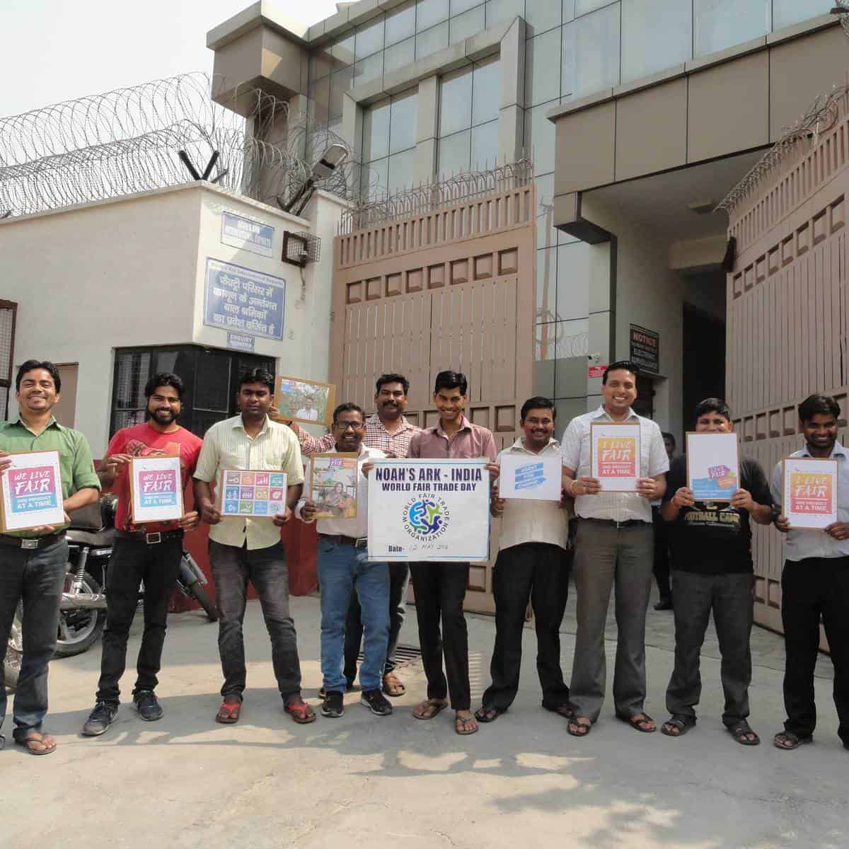 A group of people advocating Fair Trade by holding signs in front of a building.