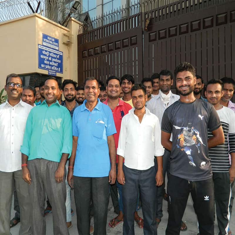 A team of men working on box and carton making in front of a building.